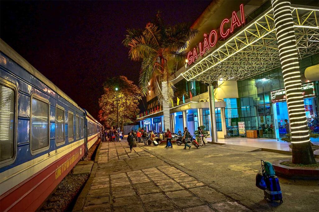 Lao Cai Railway Station at night with train of Reunification Express parked on the station at big letters of Ga Lao Cai on the station building