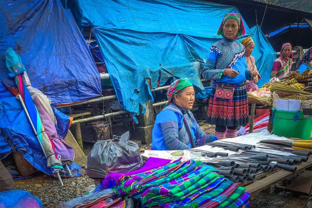 Ethnic woman on Lung Phin Market selling clothes