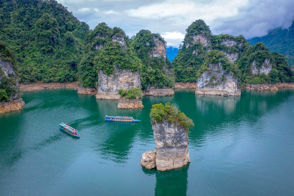 Aerial view of Na Hang Lake in Tuyen Quang with huge rocks standing out of the water and two boats doing a tour around the lake