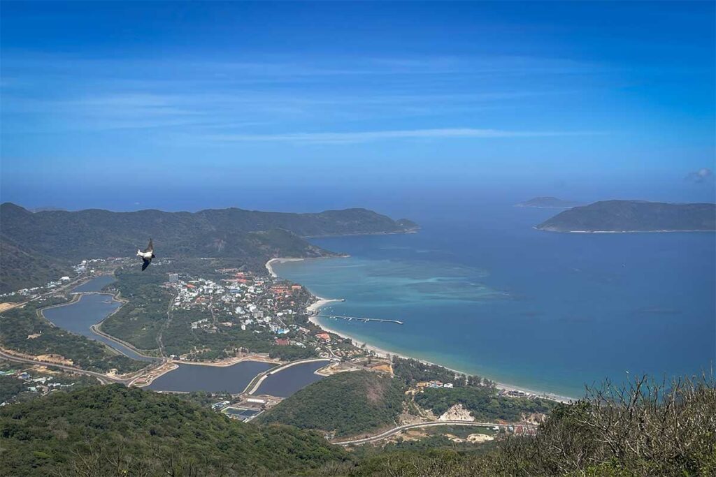 Panoramic view over Con Son Town and coastline from a high viewpoint in Con Dao National Park, with mountains, bays, and turquoise sea stretching into the distance