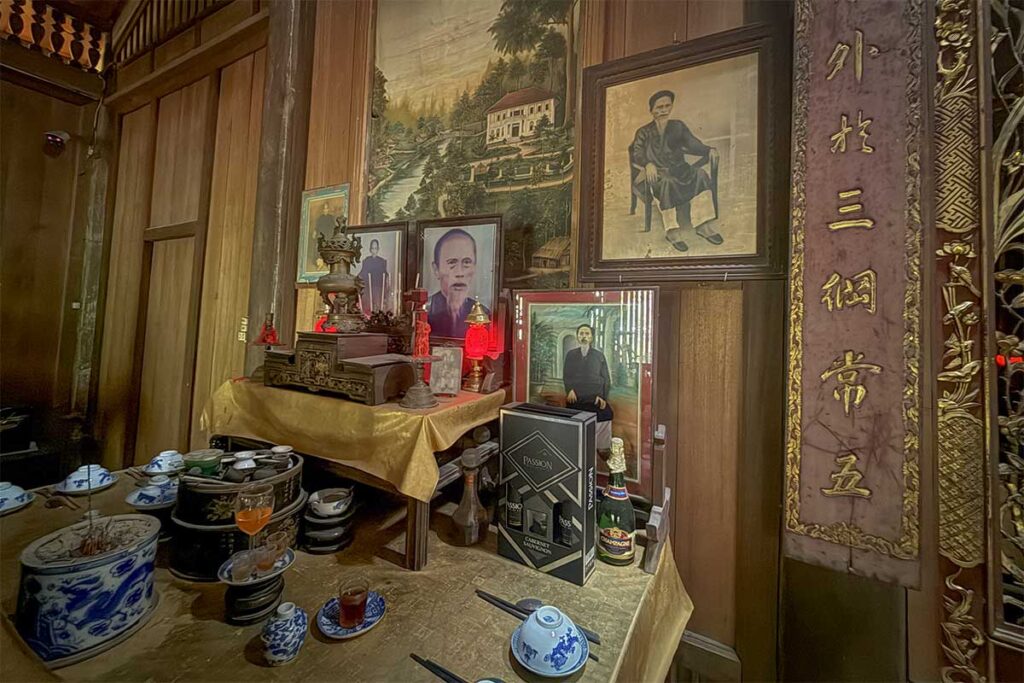 Family altar with ancestral portraits, ceramic bowls, and incense inside Ong Kiet’s Ancient House in Cai Be, preserving the traditions of southern Vietnam’s wealthy households.