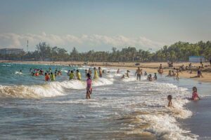 Phan Rang city beach filled with locals enjoying the waves and relaxing along the sandy shoreline.
