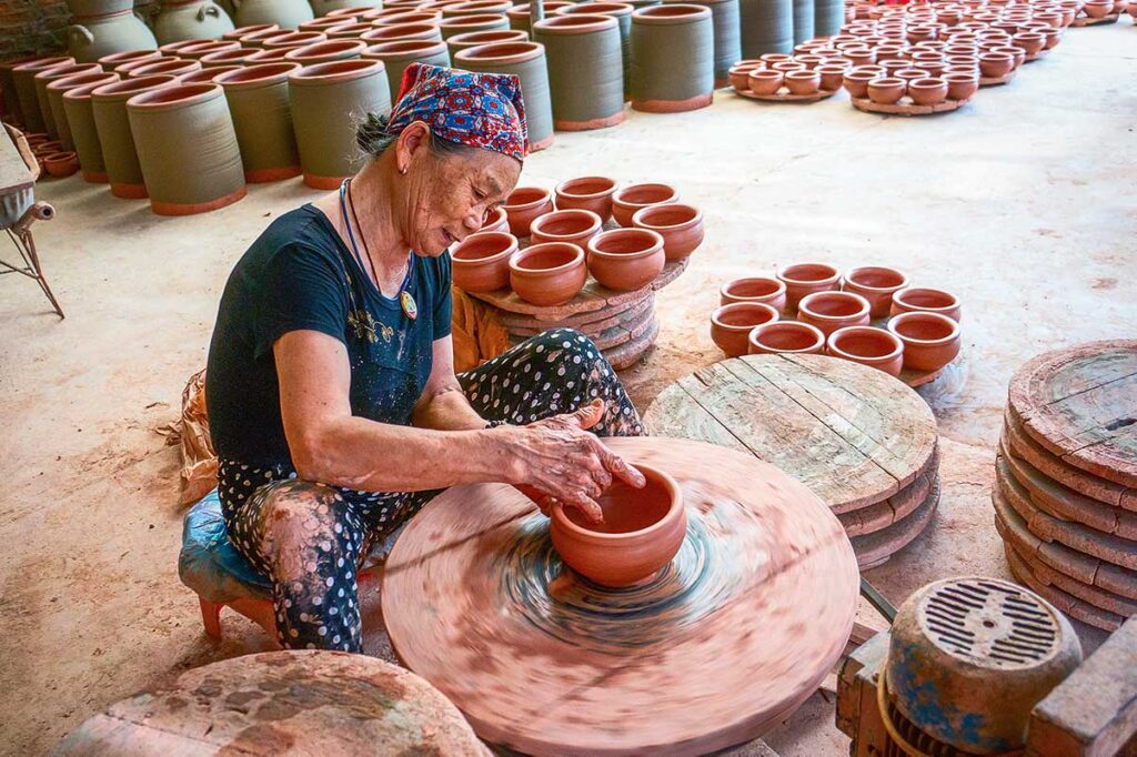 An old woman making pots in traditional way at Phu Lang Pottery Village