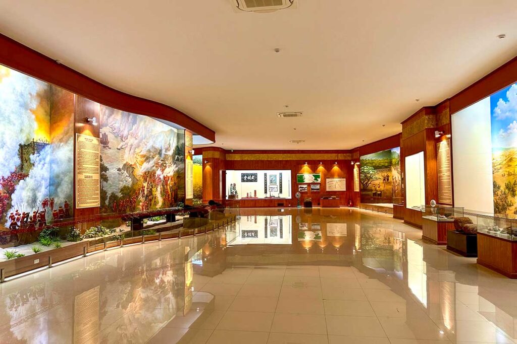 Interior exhibition hall of Quang Trung Museum, featuring painted battle scenes and displays about the Tay Son uprising.