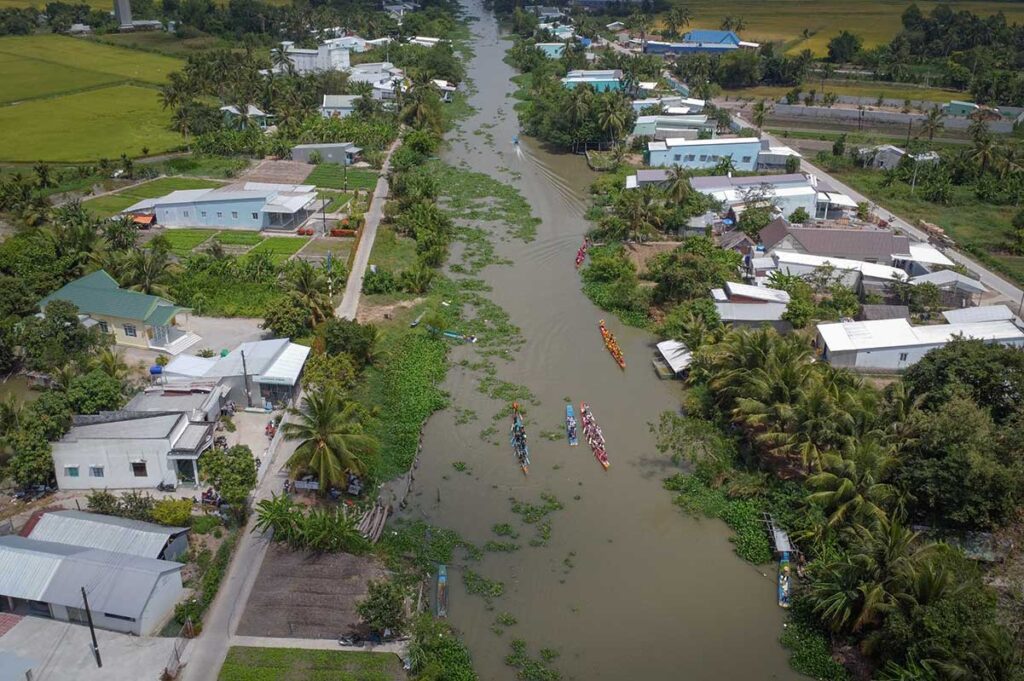 Traditional Ngo boat race in a rural canal near Rach Gia during the Ok Om Bok Festival, an iconic Khmer cultural event in Kien Giang