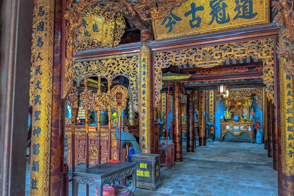 Interior of Xich Dang Temple of Literature with Chinese symbols, red and gold wooden beams and altar
