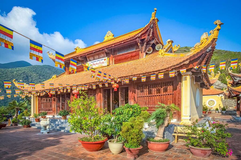 The entrance of Van Son Pagoda in Con Dao, featuring a traditional temple roof and intricate carvings, surrounded by lush greenery.