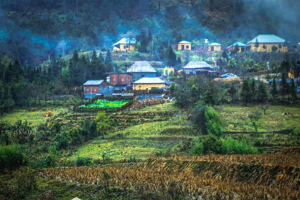 An ethnic village  with traditional houses against a mountain in Y Ty  Commune