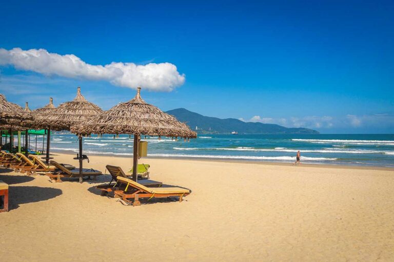 Beach with sun loungers and straw umbrellas in Da Nang, a popular coastal destination in central Vietnam