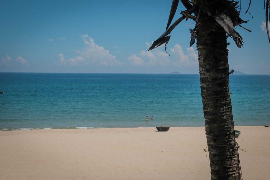 Colorful fishing boats floating on calm blue water near Hoi An during the dry months, when skies are clear and the sea is ideal for boat trips and beach visits.