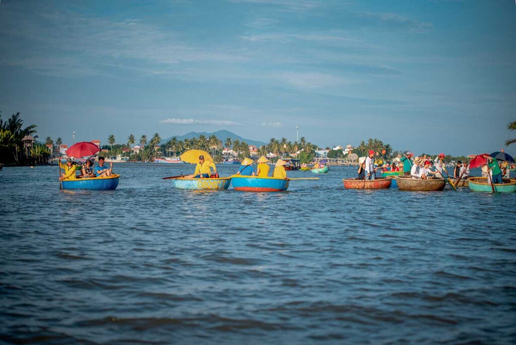 Basket boats on Hoi An’s Coconut Village river in September, with partly cloudy skies marking the start of the rainy season yet plenty of warm, calm days for boat tours.