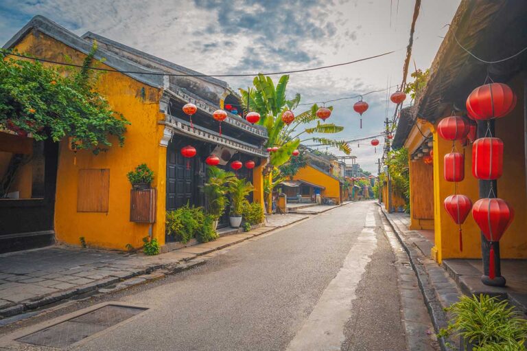 Quiet street in Hoi An Ancient Town with yellow houses and lanterns, one of the most charming places to visit in Vietnam