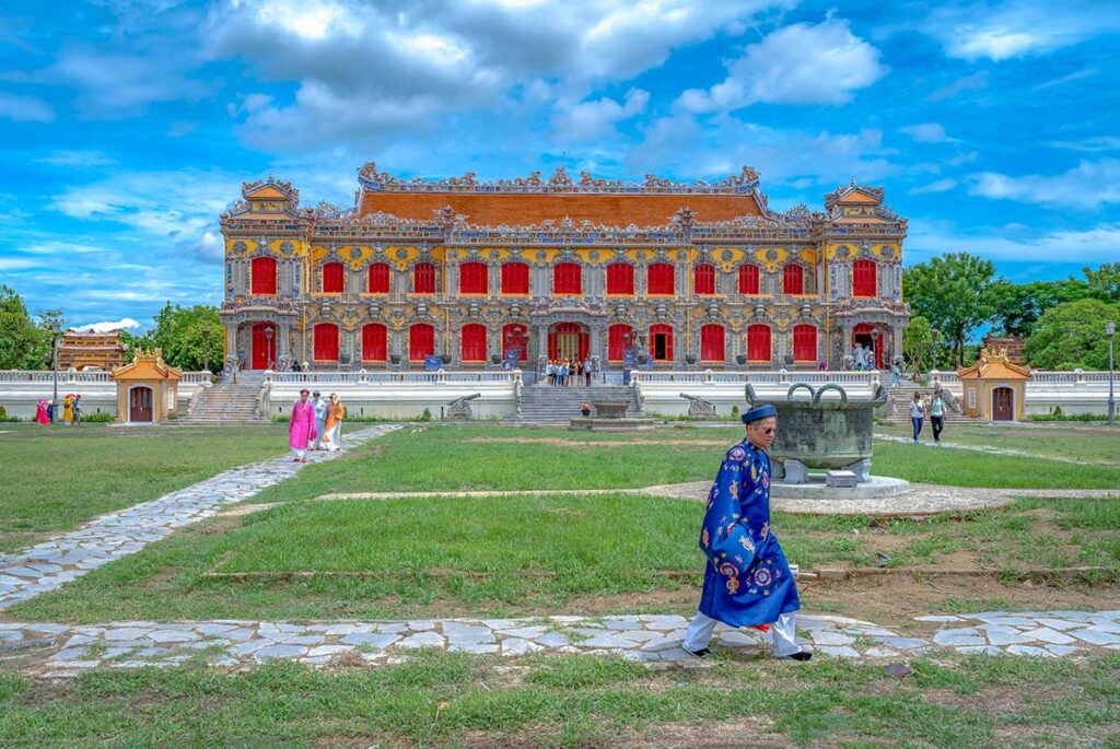 Hue in July - A man with traditional historic clothes walking on a nice weather day through Hue's Forbidden Purple City