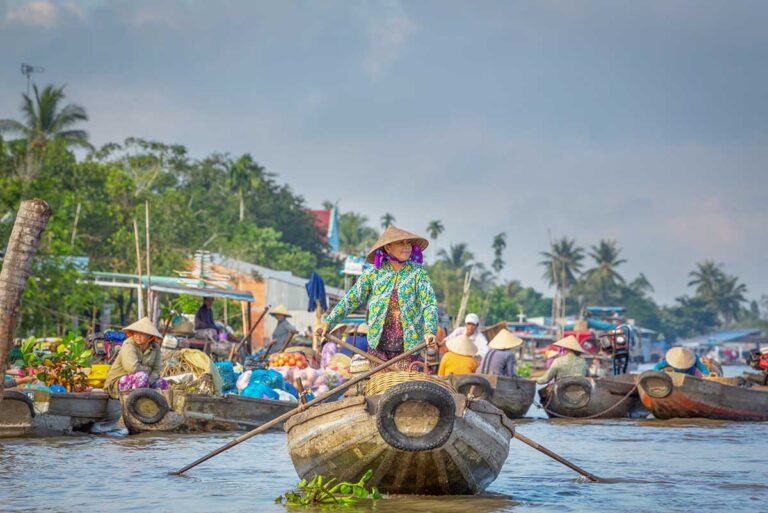 Mekong Delta floating market with local boats and vendors, showing daily life along the rivers of southern Vietnam travel