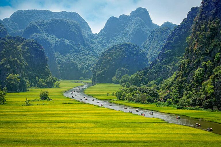 Boat ride through rice fields and limestone karst landscape in Ninh Binh, a peaceful Vietnam travel destination