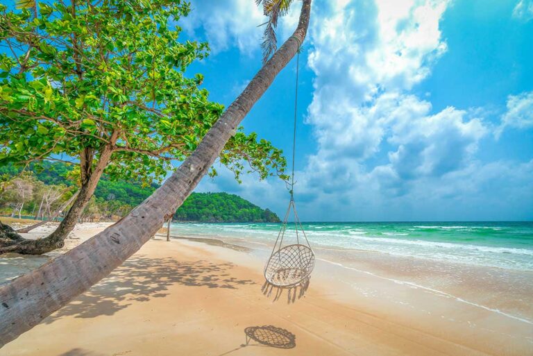 Tropical beach on Phu Quoc Island with palm trees and a swing, a popular island escape for Vietnam travel