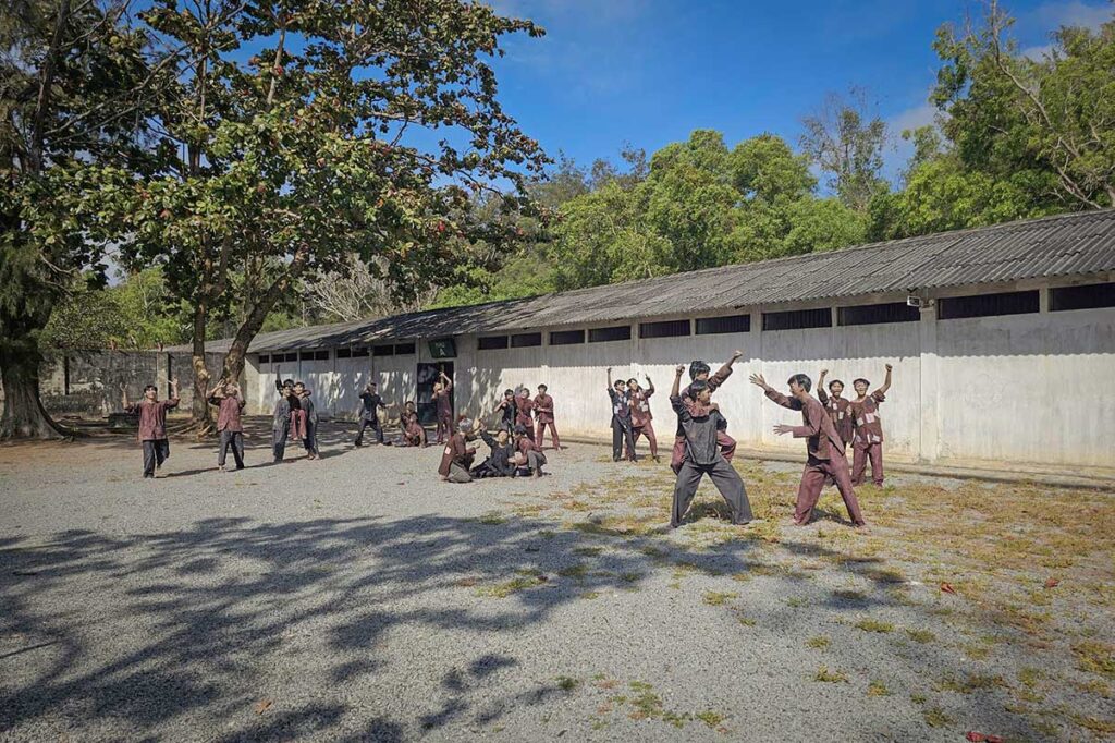 Large open yard at Phu Binh Camp with multiple prisoner reconstructions, showing the scale and organization of the American Tiger Cages at Con Dao prison.