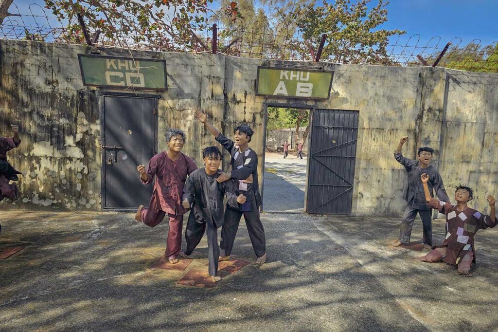 Reconstruction with prisoner figures in the courtyard of the American Tiger Cages at Con Dao prison, depicting daily life and conditions during detention.