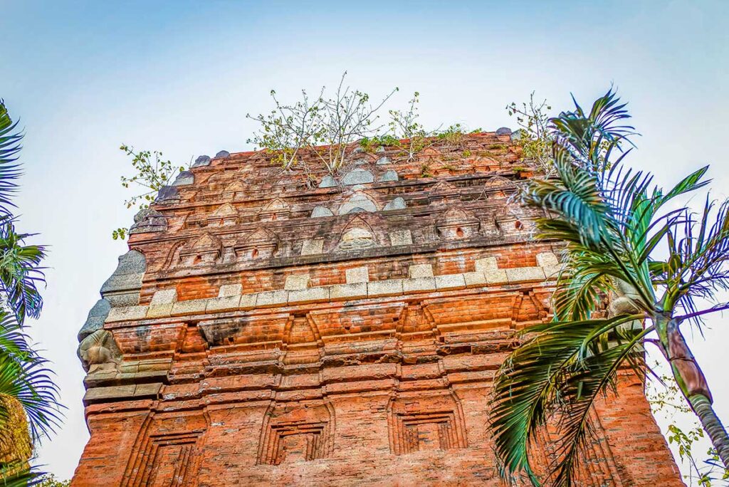 Top section of Cham Twin Towers in Quy Nhon – Khmer-influenced design with layered brickwork and Garuda figures visible at the corners.
