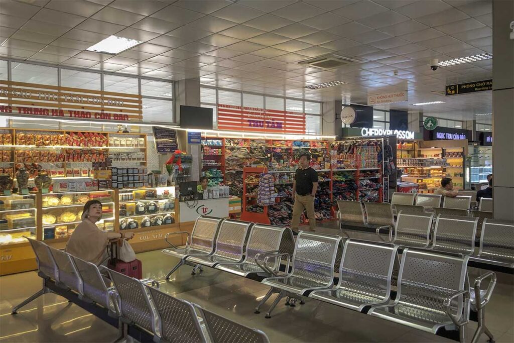 Inside Con Dao Airport terminal showing seating area and small souvenir shops with snacks and local products
