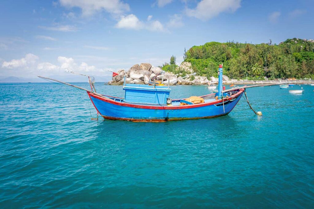 Bright blue wooden fishing boat anchored off Cu Lao Xanh Island.