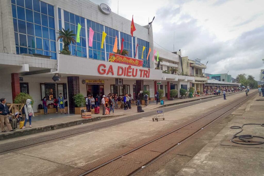 Busy day at Diêu Trì Train Station – crowds of passengers with luggage waiting outside the main station building, highlighting its role as Quy Nhon’s main rail gateway.