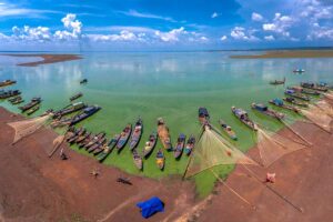 Fishing boats are docked along the shore of Tri An Lake