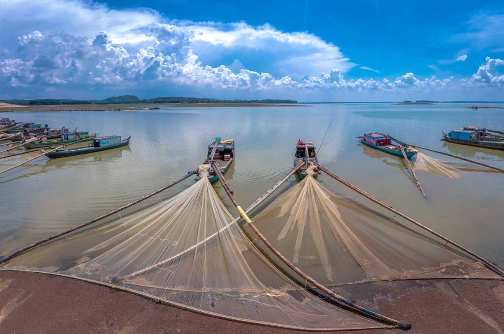 Fishing boats with large nets along the shores of Tri An Lake