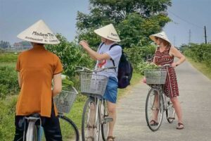 Travelers stopping to pick herbs and vegetables while cycling through Hue’s countryside villages.
