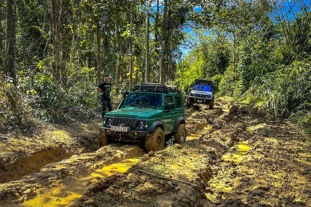 Two jeeps on a dirt road within Ma Da Forest