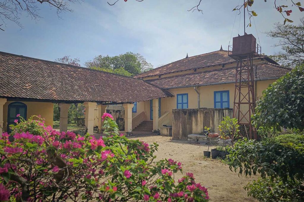 Exterior view of the Palace of the Island Governor in Con Dao, surrounded by gardens and historic buildings that once housed colonial authorities overseeing the prison complex.