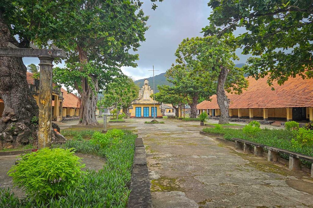 Central courtyard of Phu Hai Prison on Con Dao surrounded by long prison buildings and trees, illustrating the layout of one of the main camps within the Con Dao prison system.