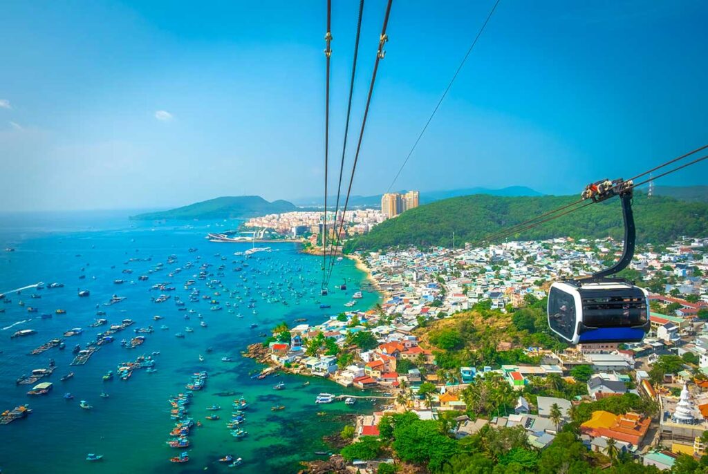 Cable car above the sea in Phu Quoc with panoramic views of fishing boats, coastal town, and surrounding islands