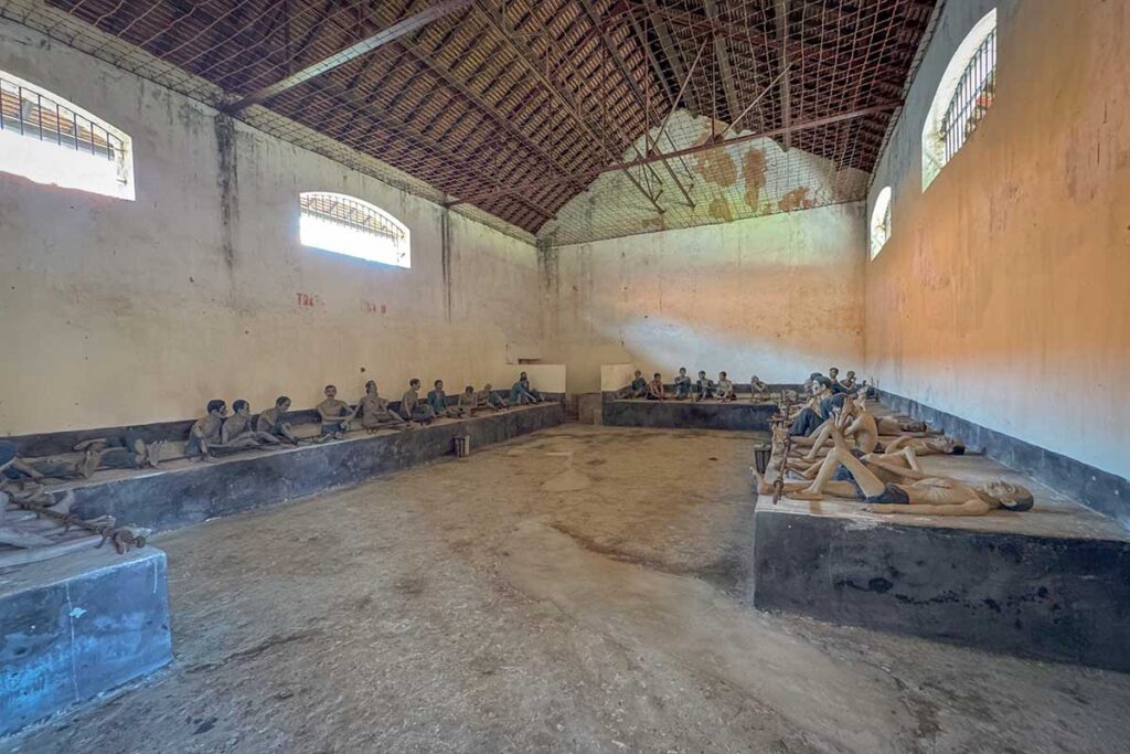 Large interior hall at Phu Son Prison on Con Dao with prisoner reconstructions, illustrating how detainees were held together in shared spaces rather than isolated cells.