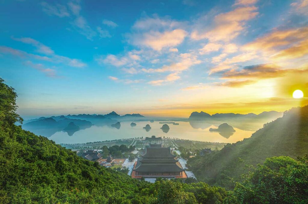 View from top of the hills overseeing the complex of Tam Chuc Pagoda, with several temples below and the lake with small islands