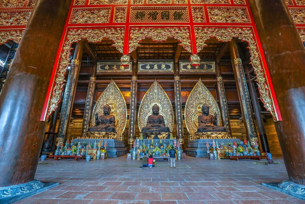 Three enormous bronze Buddha statues inside Tam The Temple part of Tham Chuc Pagoda Complex
