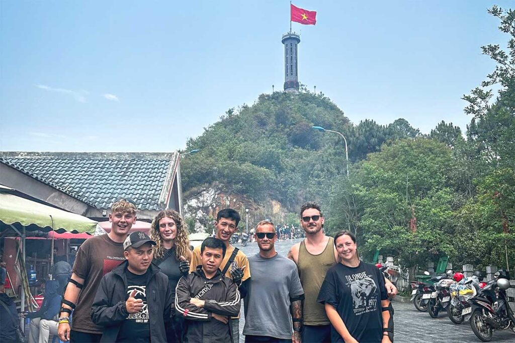 Easy Rider motorbike tour group posing near Lung Cu Flag Tower in Ha Giang