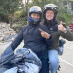 Tourist giving thumbs up while riding with Easy Rider on Ha Giang Loop motorbike tour