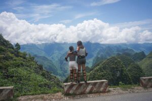 Two women in motorbike gear posing with mountain views during Ha Giang motorbike tour