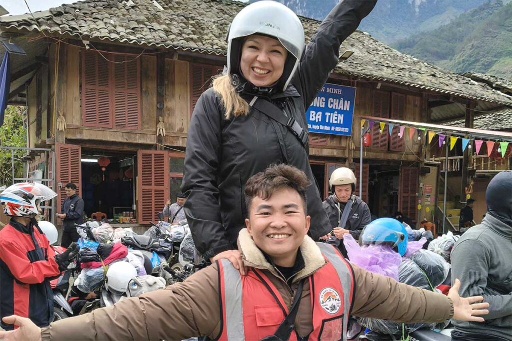 Tourist and Easy Rider celebrating with arms wide open on a Ha Giang Loop motorbike adventure