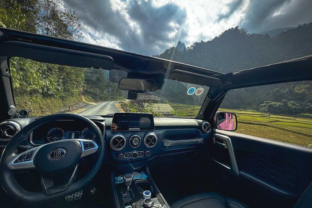 View from inside a modern open jeep during a Ha Giang Loop tour through the mountains