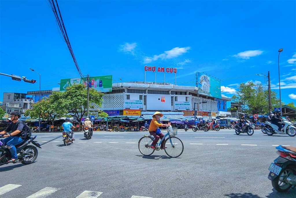 A local on a bicycle biking in front of An Cuu Market