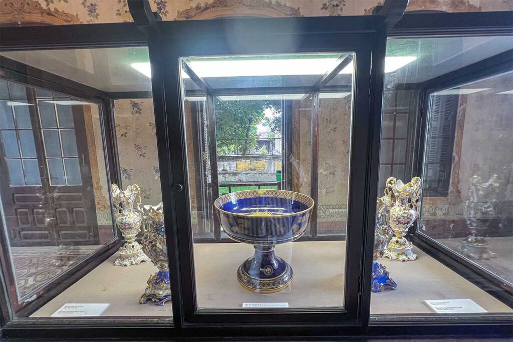 Small exhibit behind glass as part of the museum inside An Dinh Palace