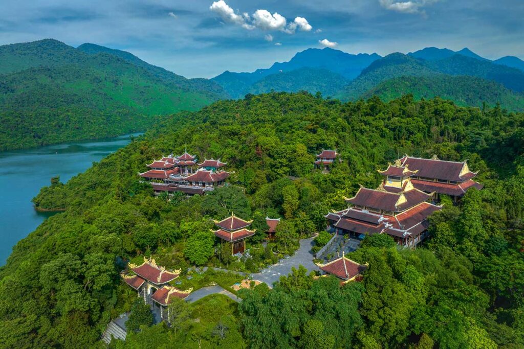 The Bach Ma Zen Monastery seen from the air, hidden between trees and behind a lake