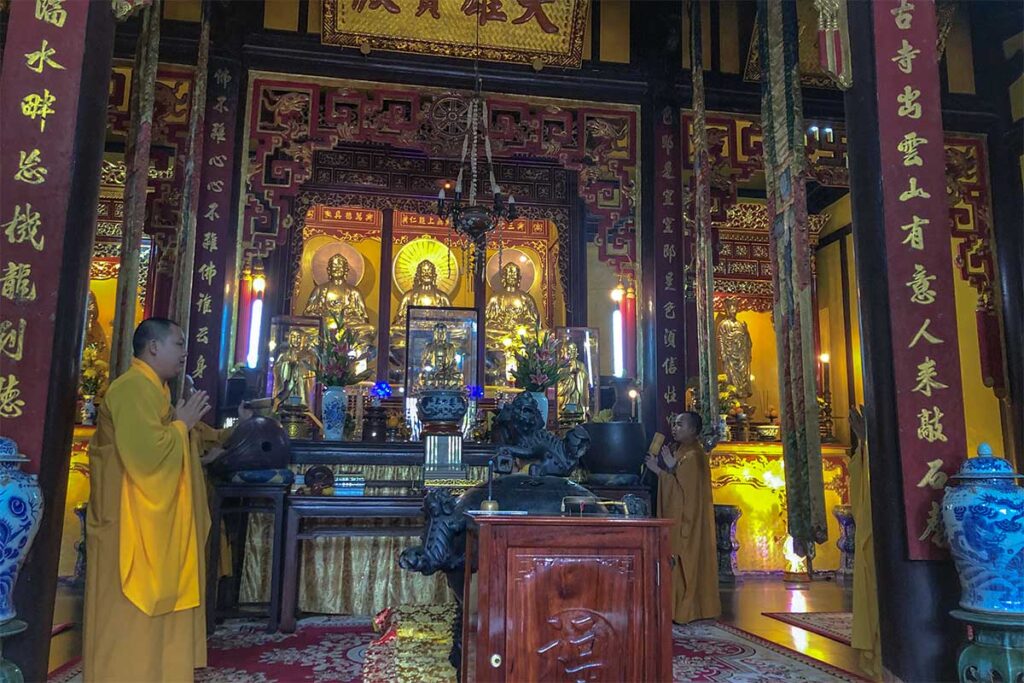 Buddhist monks are praying inside the main hall of Bao Quoc Temple in Hue