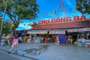 The exterior of Dong Ba Market with a large red sign on the building that says "Cho Dong Ba"