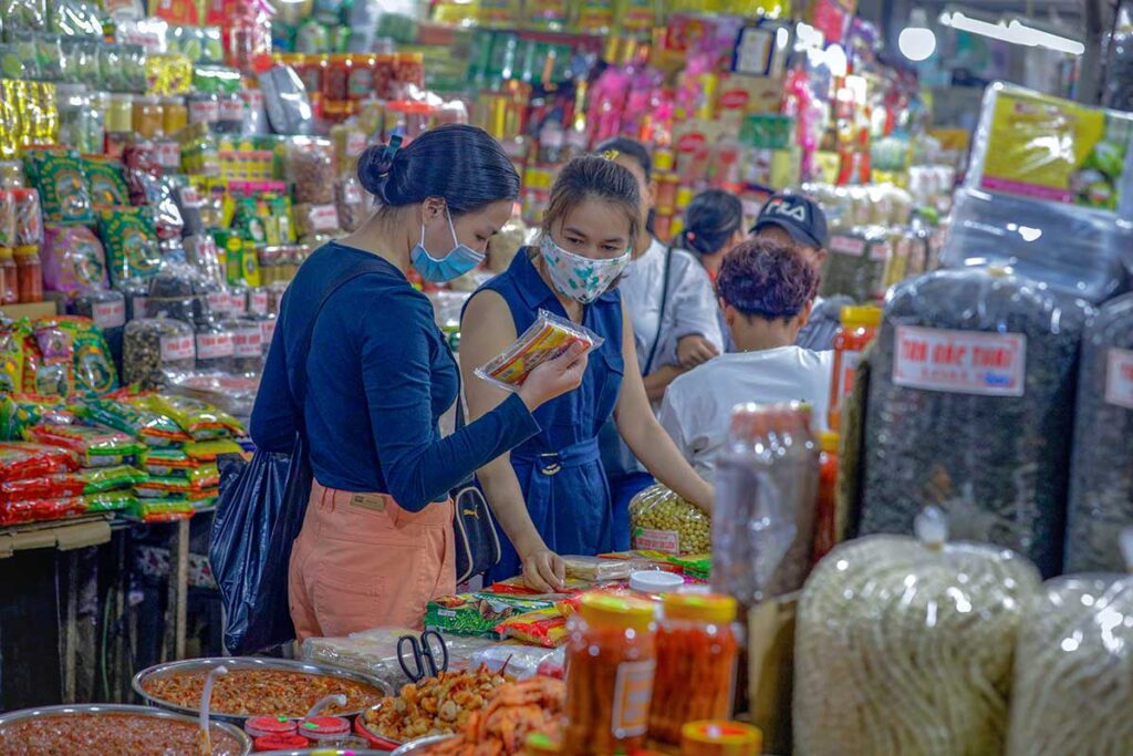 Locals checking products at a market stall inside Dong Ba Market in Hue