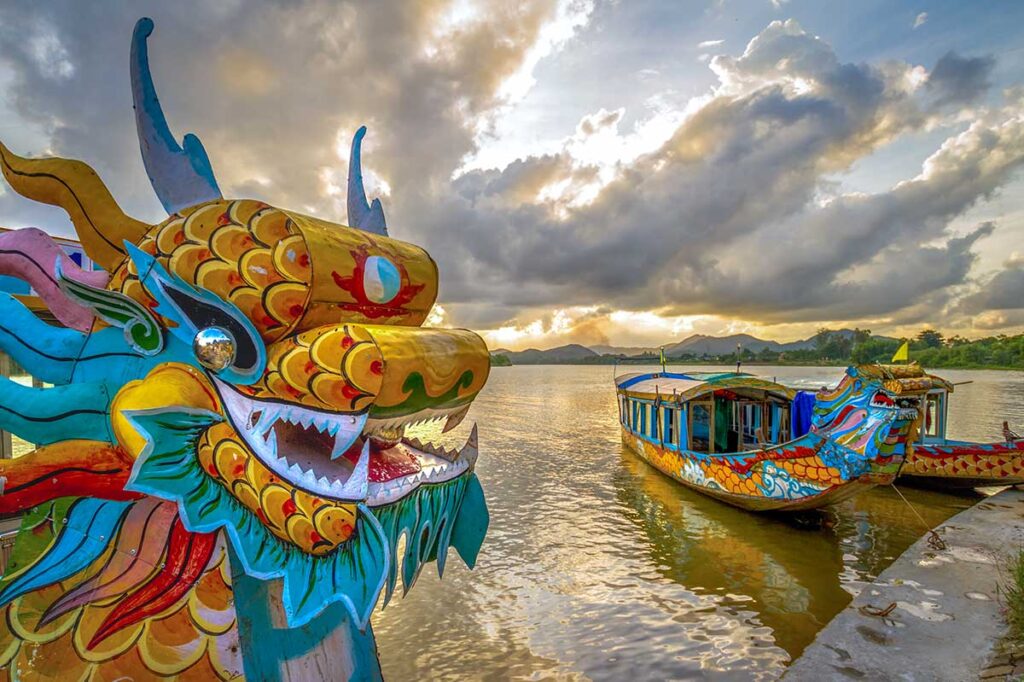 Two dragon boats are docked at a wharf in Hue