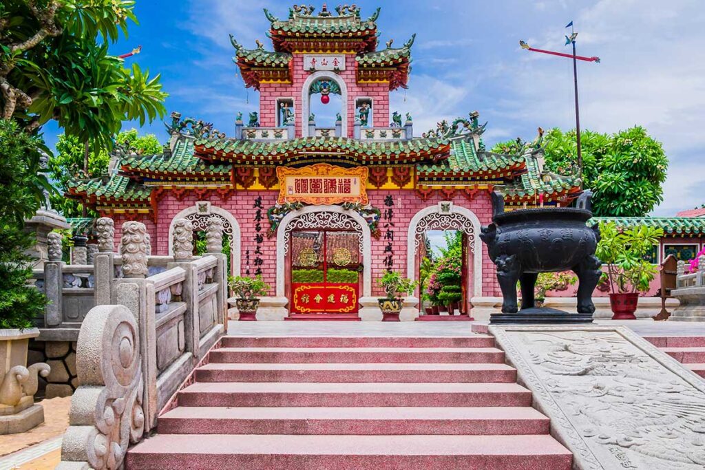 The ornate Fujian Assembly Hall in Hoi An Old Town, featuring colorful Chinese architecture, dragon motifs, and a detailed gate with red and green tiles.