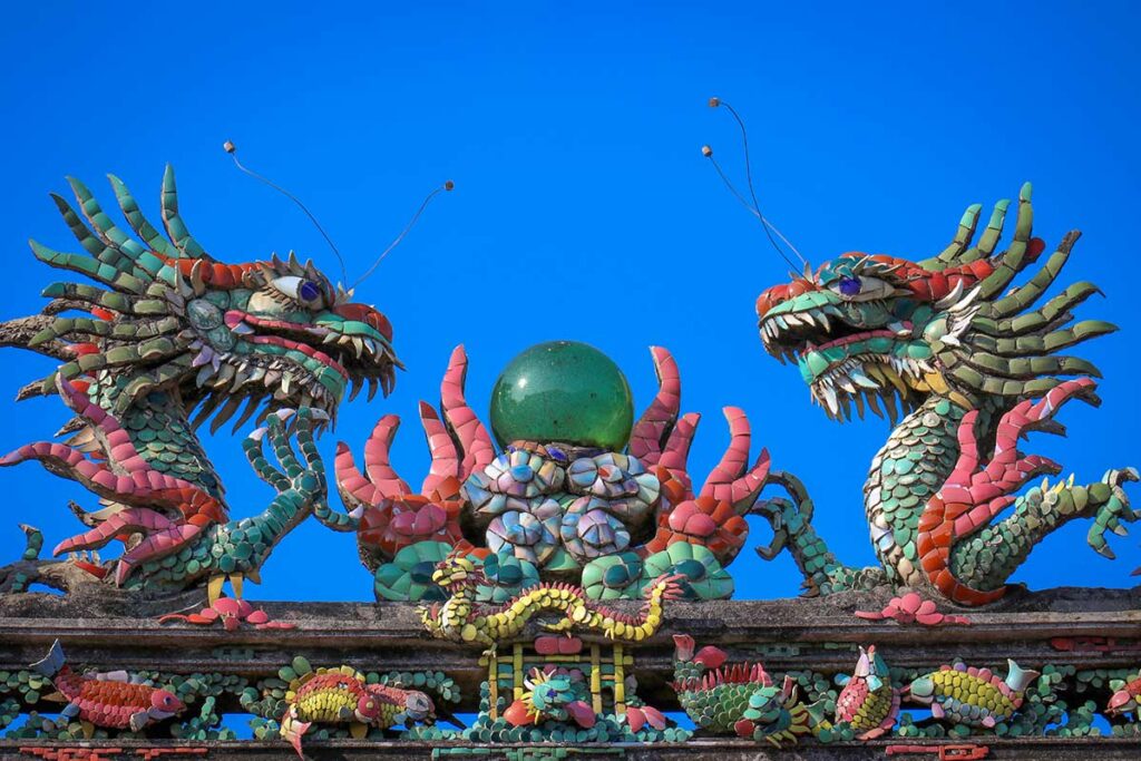 Ornate dragon mosaic at Fujian Assembly Hall (Phuc Kien) in Hoi An, with colorful ceramic details and symbolic pearl.